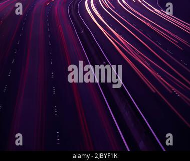 Traffico che scorre in entrambe le direzioni sull'autostrada al tramonto Foto Stock