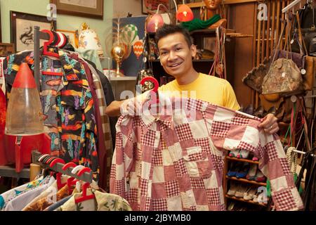 Uomo malese shopping nel negozio vintage Foto Stock