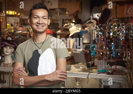 Malaysian uomo che lavora nel negozio vintage Foto Stock