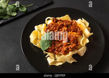 Pappardelle con prosciutto e formaggio in salsa di una piastra. Alimenti e bevande Foto Stock