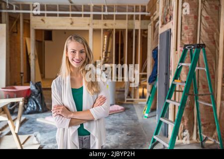 Donna sorridente al sito in costruzione Foto Stock