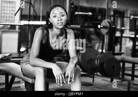 Donna africana seduta sul banco di peso Foto Stock