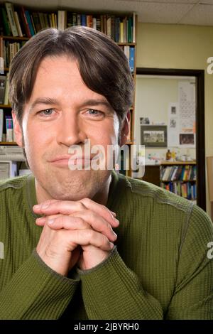 Sorridente razza mista uomo con le mani incrociate Foto Stock