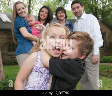 Famiglia in piedi nel cortile anteriore insieme Foto Stock