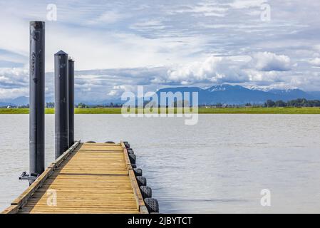 Una rampa per barche e un molo galleggiante su un fiume o un lago. Molo di legno su un'acqua. Foto di viaggio, nessuno, spazio di copia per il testo. Foto Stock