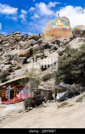 Dipinti buddisti tibetani su pietre di mani (om mani padme hum) nel monastero di Drepung del ai piedi del monte Gephel a Lhasa, Tibet. Foto Stock