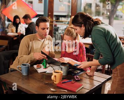 Giovane ordinare del cibo al Cafe Foto Stock