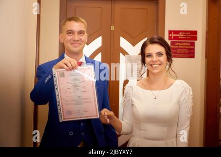 Kirov, Russia - 10 agosto 2021: La sposa e lo sposo durante la bella cerimonia di matrimonio presso l'ufficio di registrazione in Russia. Il concetto di amore e famiglia Foto Stock