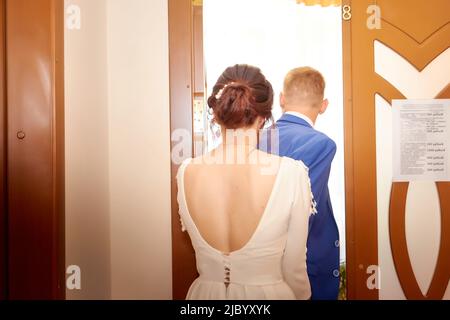 Kirov, Russia - 10 agosto 2021: La sposa e lo sposo durante la bella cerimonia di matrimonio presso l'ufficio del registro in Russia. Il concetto di amore e. Foto Stock