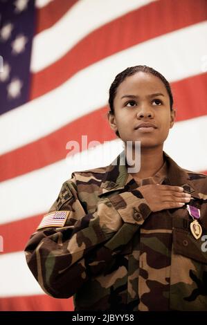 Ispanico soldato femmina nella parte anteriore della bandiera americana Foto Stock