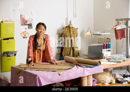 Femmina asiatica stilista di moda in officina Foto Stock