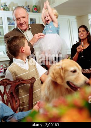 Famiglia multi-generazionale e cane in cucina Foto Stock