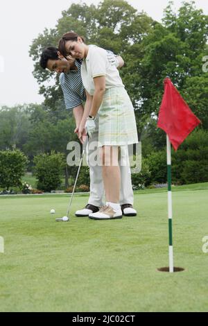 Giovane giocando a golf insieme Foto Stock