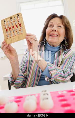 Donna anziana vincita al bingo Foto Stock