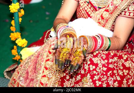 Una sposa indiana che mostra il design dei tatuaggi mehndi della sua mano Foto Stock