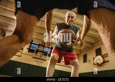 Uomini anziani giocare a basket Foto Stock