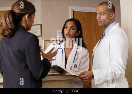 Medici e imprenditrice esaminando una brochure Foto Stock