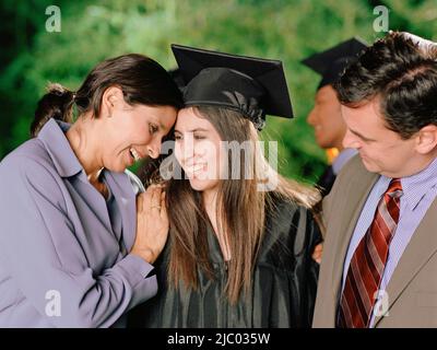 La madre e il Padre abbracciando graduate figlia Foto Stock