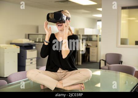 La donna sembra sorpresa quando indossa un visore VR. Foto Stock