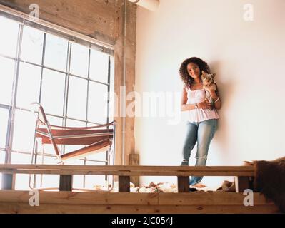 Giovane donna azienda cane Foto Stock