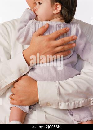 Padre holding bambina tra le sue braccia Foto Stock