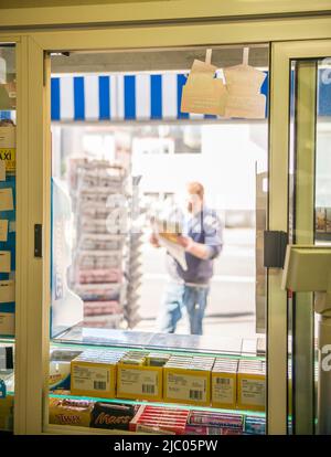 Kiosk e Man che leggono un giornale in Svizzera. Foto Stock