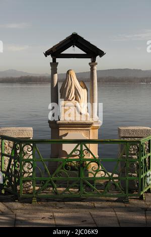 Madonna sul lungomare sul Lago Alpino maggiore in una giornata di sole ad Arona, Piemonte in Italia. Foto Stock