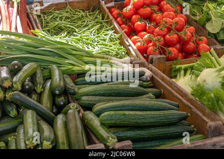 Ortaggi freschi in vendita in un negozio all'aperto nei Paesi Bassi. Pomodori, cetrioli, zucchine e cipolle fresche, vista ravvicinata. Foto Stock