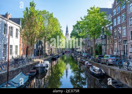Barche ormeggiate lungo il canale, Amsterdam. Biciclette e auto parcheggiate sulla strada, case tradizionali olandesi, quartiere residenziale Foto Stock