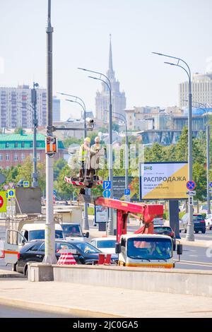 Mosca. Russia. Giugno 9, 2022. I lavoratori di una torre mobile riparano una telecamera TVCC su un palo della città. Messa a fuoco selettiva. Foto Stock