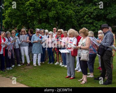 Il coro amatoriale, tutti i membri del U3A, cantano in occasione di un evento per celebrare il Giubileo del platino della Regina, Abington Park, Northampton, Regno Unito Foto Stock