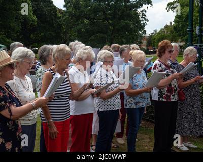 Il coro amatoriale, tutti i membri del U3A, cantano in occasione di un evento per celebrare il Giubileo del platino della Regina, Abington Park, Northampton, Regno Unito Foto Stock