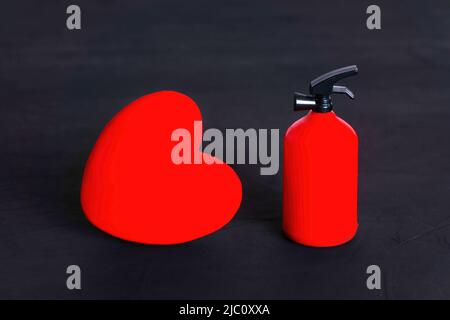 Grande forma a cuore rosso e un estintore giocattolo su sfondo nero.  Concetto di relazione appassionato Foto stock - Alamy