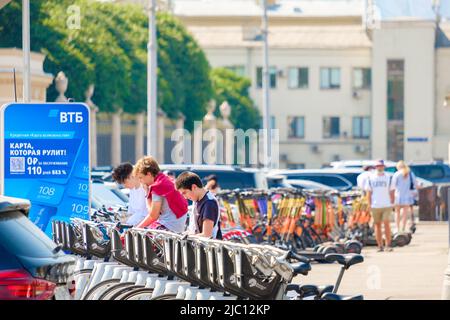 Mosca. Russia. Giugno 9, 2022. Un ragazzo giovane nel parcheggio sceglie una bicicletta a noleggio. Messa a fuoco selettiva. Trasporti pubblici rispettosi dell'ambiente in una giornata estiva di sole su una strada a Mosca. Foto Stock