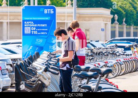 Mosca. Russia. Giugno 9, 2022. Un giovane sceglie una bicicletta da affittare in una giornata estiva di sole su una strada a Mosca. Messa a fuoco selettiva. Trasporti pubblici rispettosi dell'ambiente in città. Foto Stock