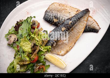 Due filetti di sgombro cotti su un piatto Foto Stock