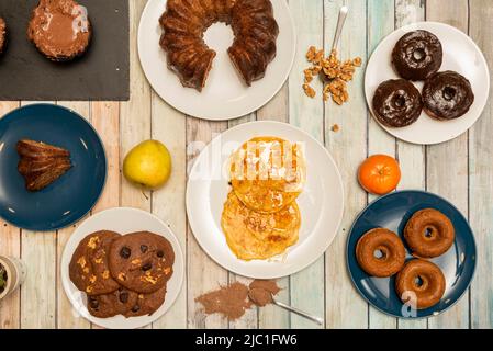 Set di dolci, torte e colazioni, ciambelle di cioccolato e zucchero, frutta candita, pancake con sciroppo, cupcake, torte al cioccolato Foto Stock