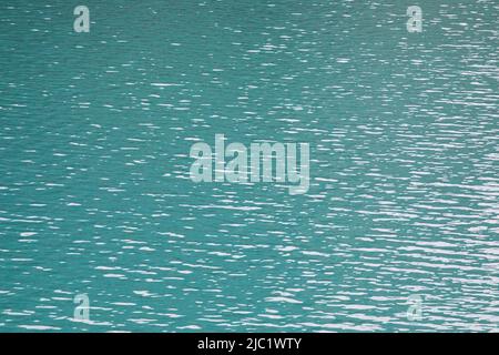 Texture sfondo di acqua turchese superficie con ondulazione e riflessi chiari. Foto Stock
