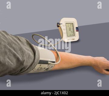 Controllo dello stato di pressione sanguigna e frequenza cardiaca a casa con il dispositivo medico digitale per il test della pressione sanguigna. Salute e concetto medico. Immagine da vicino. Foto Stock