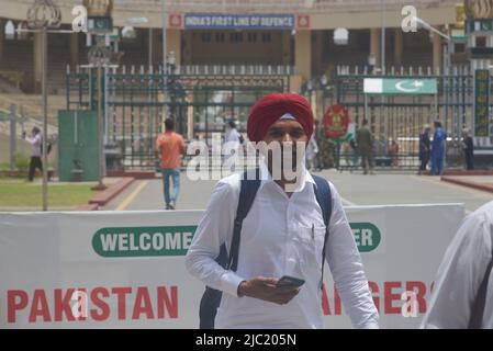 Wagah Boarder, Pakistan, 08/06/2022, pellegrini sikh indiani che entrano in Pakistan attraverso Wagah Boarder per partecipare al riferimento di condolence 416th (Jor Mela) di Guru Arjan Dev Ji a Lahore. Un gran numero di Sikh Yatrees sono arrivati in Pakistan attraverso il confine di Wagha per partecipare a riti religiosi in occasione di Joor Mela.Sikh da tutto il paese e all'estero riversati in Gurdwara Punja Sahib a Hassanabdal, il terzo luogo più sacro della religione Sikh, per marcare Shaheedi Jor Mela, Il 416th anniversario della morte del quinto guru del Sikh 11, Guru Arjan Dev Ji. (Foto di Rana Sajid Hussain/Pacific Pr Foto Stock