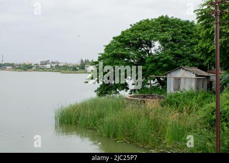 Una capanna sulla riva di un lago. Vista dall'India. Foto Stock