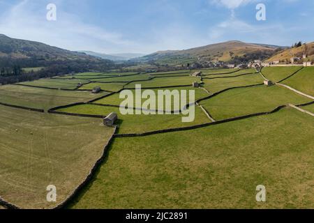 vista rialzata dei campi di patchwork e dei tradizionali granai di pietra sul gunnerside nello swaledale nord dello yorkshire Foto Stock