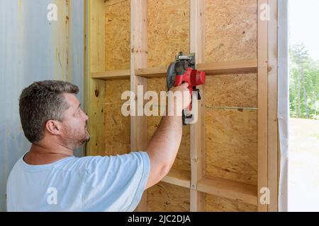 Lavoratori edili con sega circolare elettrica a mano per tagliare assi in legno Foto Stock
