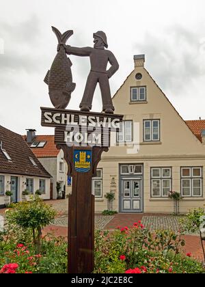 Schleswig, Schleswig-Holstein, Germania - 13 agosto 2021: Cartello di legno all'ingresso dell'ex villaggio di pescatori di Holm, un distretto dello Schleswig Foto Stock