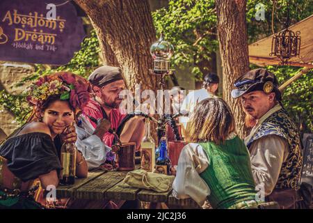 6-4-2022 Muskogee USA - Gruppo di amici al tavolo da picnic al Dream Hooka di Absalom e stabilimento del tè fumando e bevendo - vestito in cos medievale Foto Stock