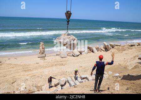 Gaza. 9th giugno 2022. Ingegneri e lavoratori palestinesi utilizzano gru per porre blocchi di cemento per prevenire l'erosione costiera, a Gaza, il 9 giugno 2022. Credit: Rizek Abdeljawad/Xinhua/Alamy Live News Foto Stock