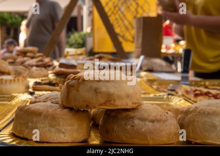 Primo piano di dolci fatti con pasta di lardo, farciti di carne, piselli e sobrasada, chiamati panades. Gastronomia tipica dell'isola di Maiorca, Spagna Foto Stock