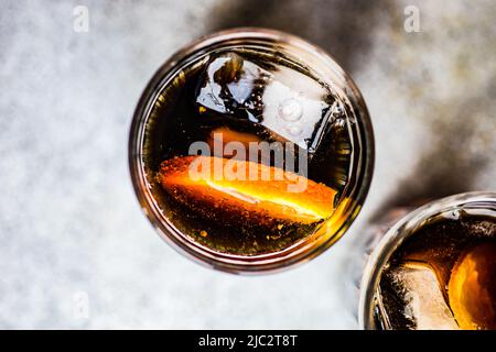 Vista dall'alto di due bibite con cubetti di ghiaccio e fette di arancia fresca Foto Stock