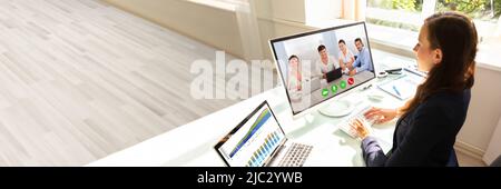 Vista laterale di una giovane imprenditrice la videoconferenza con i suoi colleghi sul computer Foto Stock