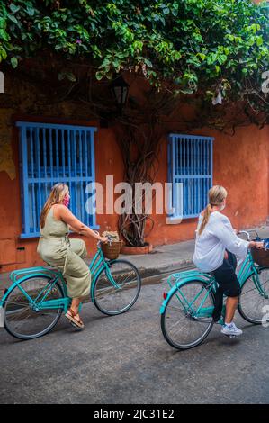 Due giovani donne che cavalcano la loro bicicletta nella città vecchia fortificata di Cartagena de Indias, Colombia Foto Stock